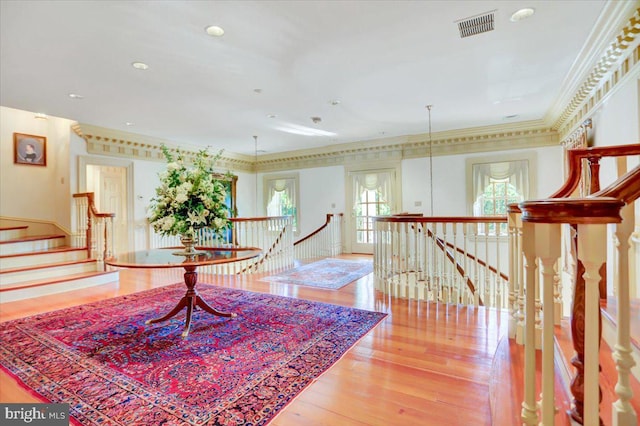 interior space with wood-type flooring and crown molding