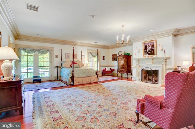 bedroom with crown molding, hardwood / wood-style floors, and a chandelier