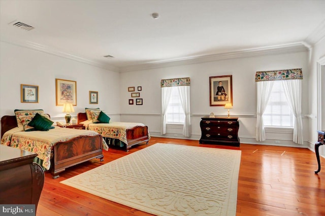 bedroom featuring hardwood / wood-style floors, multiple windows, and ornamental molding