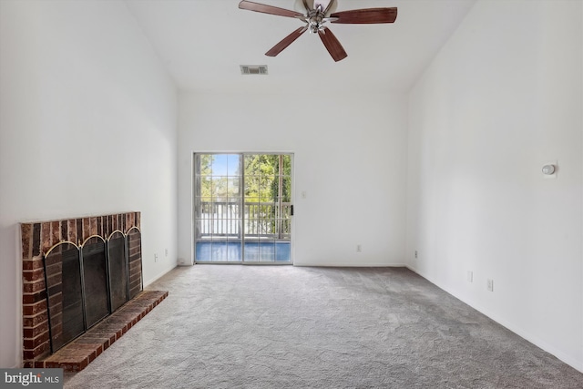 unfurnished living room with a brick fireplace, carpet, and ceiling fan