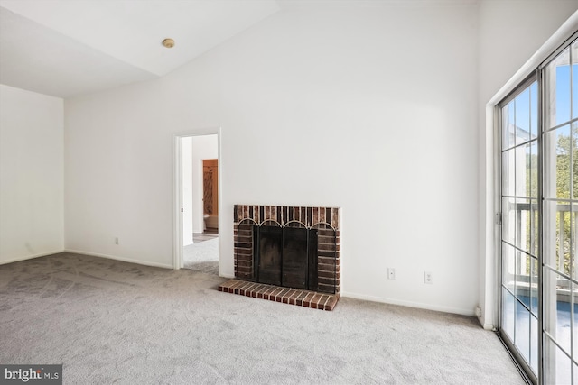 unfurnished living room with high vaulted ceiling, light colored carpet, and a brick fireplace