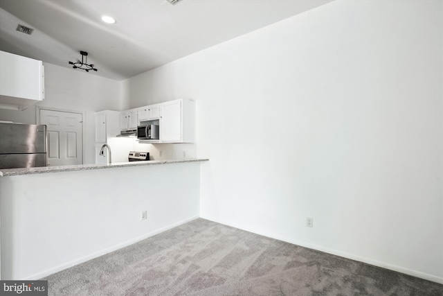 kitchen with sink, white cabinets, lofted ceiling, carpet floors, and appliances with stainless steel finishes