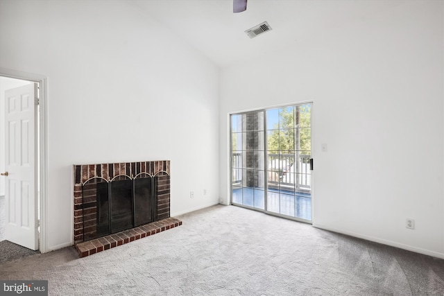 unfurnished living room with carpet floors, a brick fireplace, and high vaulted ceiling