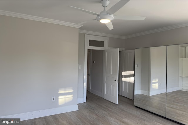 unfurnished bedroom featuring ceiling fan, a closet, crown molding, and light wood-type flooring