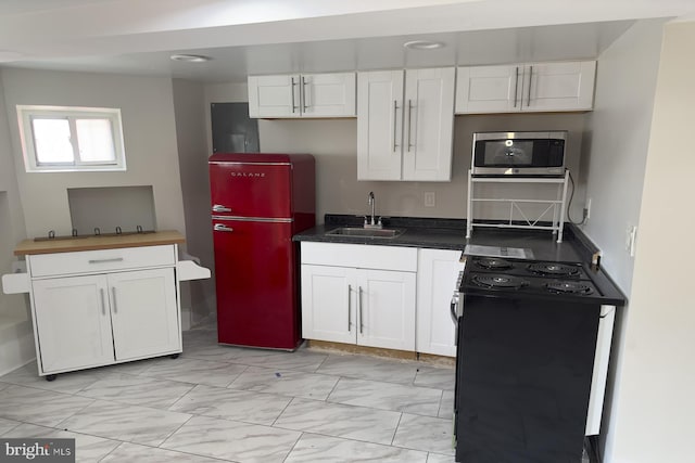 kitchen featuring white cabinets, black range with electric cooktop, refrigerator, and sink