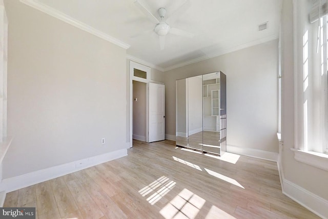 unfurnished bedroom featuring ceiling fan, light hardwood / wood-style floors, ornamental molding, and multiple windows