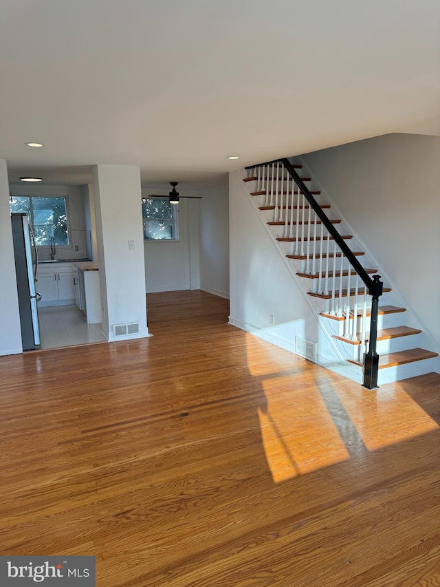 unfurnished living room with ceiling fan and light hardwood / wood-style flooring