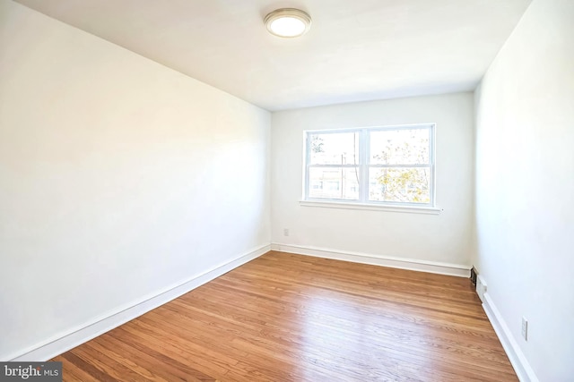 empty room featuring baseboards and wood finished floors