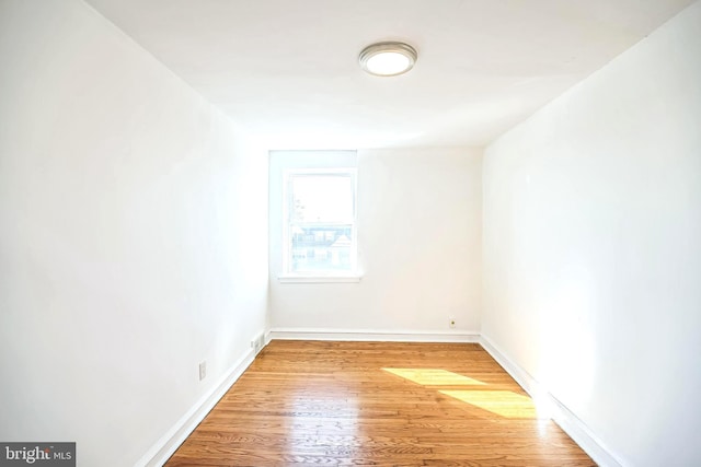 spare room with wood finished floors and baseboards