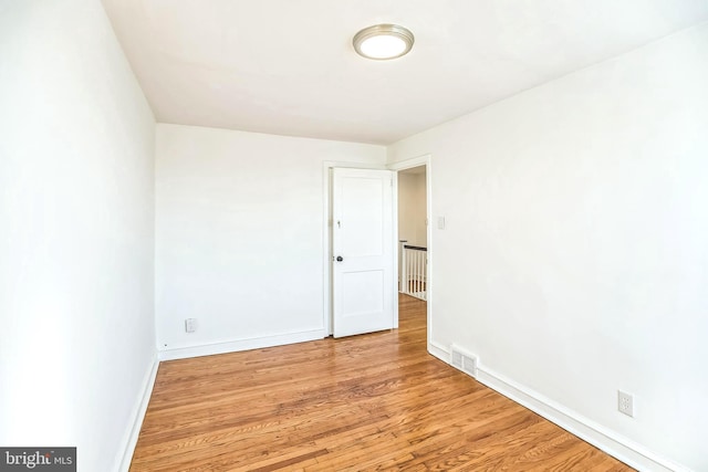 spare room with visible vents, wood finished floors, and baseboards