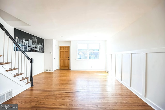 interior space featuring visible vents, stairway, and wood finished floors