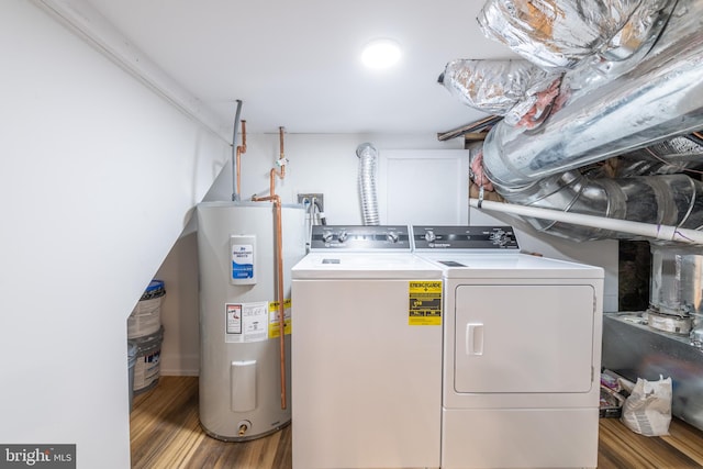 clothes washing area featuring electric water heater, washing machine and clothes dryer, and hardwood / wood-style flooring