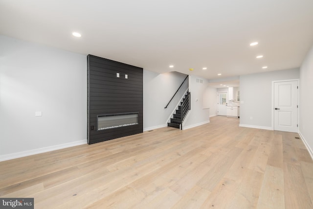 unfurnished living room featuring a fireplace and light wood-type flooring