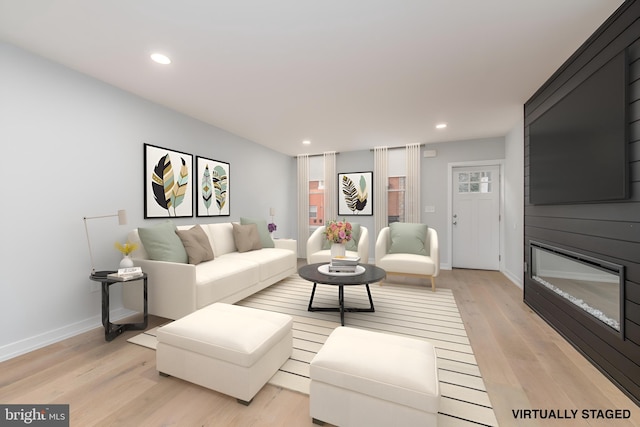 living room featuring a large fireplace and light hardwood / wood-style floors