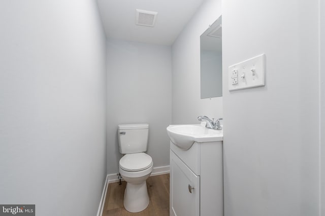 bathroom with vanity, toilet, and wood-type flooring