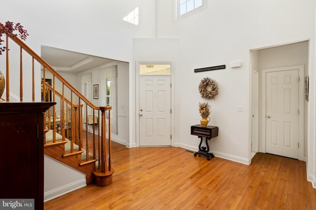 foyer with a high ceiling and light wood-type flooring