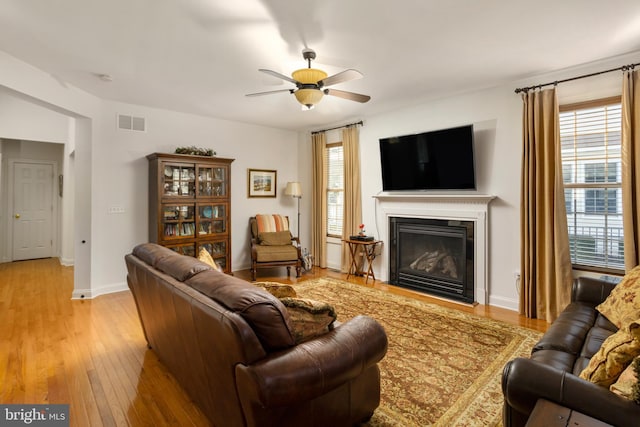 living room with ceiling fan, light hardwood / wood-style flooring, and a wealth of natural light