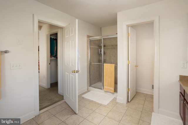 bathroom featuring vanity, tile patterned floors, and a shower with shower door