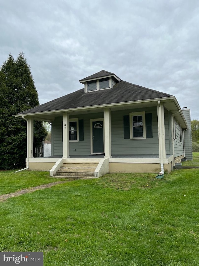 view of front of property with covered porch and a front yard