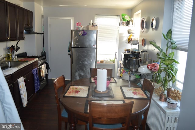 dining area featuring radiator, sink, and dark wood-type flooring