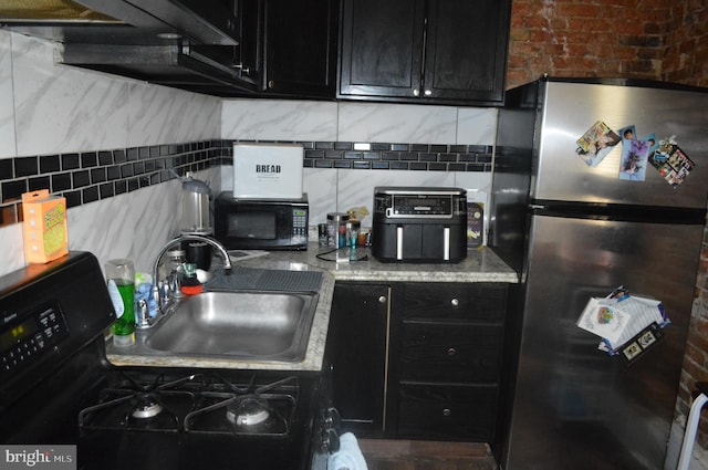 kitchen featuring tasteful backsplash, black appliances, brick wall, and sink