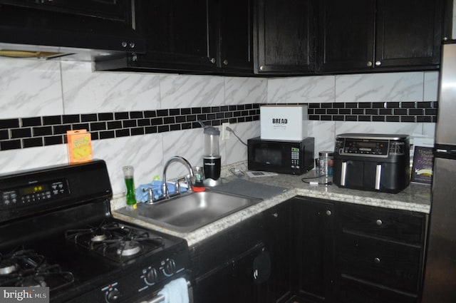 kitchen with tasteful backsplash, light stone countertops, black appliances, sink, and ventilation hood