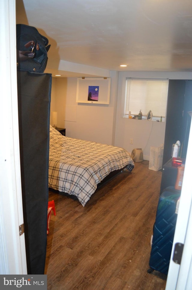 bedroom with dark hardwood / wood-style floors