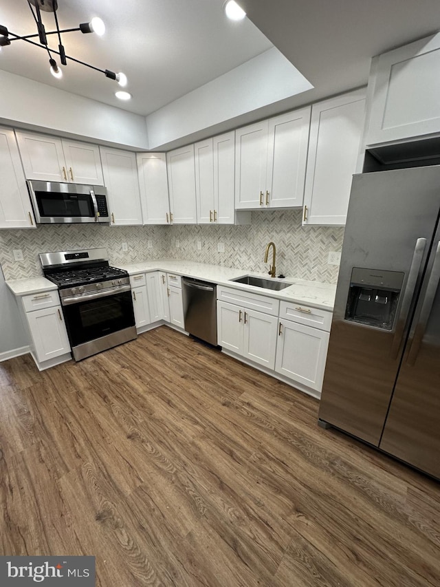 kitchen featuring stainless steel appliances, sink, and white cabinetry