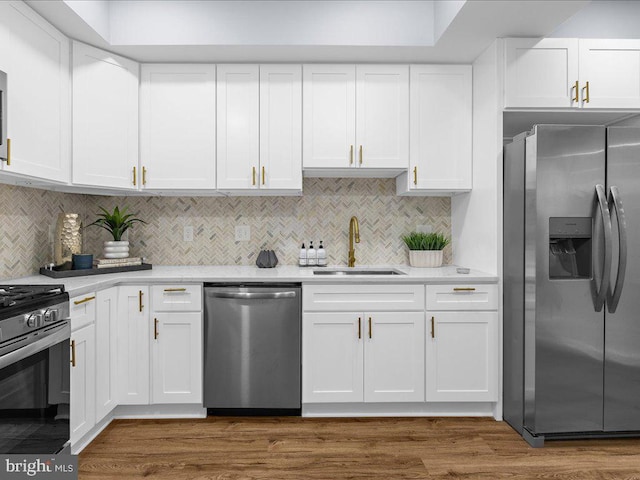 kitchen with white cabinets, appliances with stainless steel finishes, dark wood-type flooring, and sink