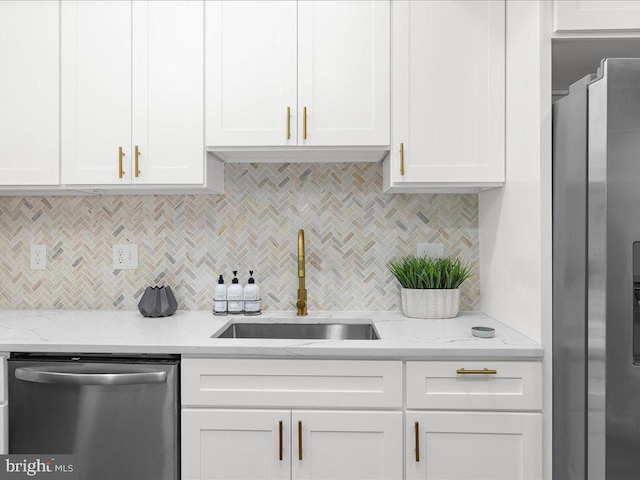 kitchen featuring light stone countertops, appliances with stainless steel finishes, sink, and white cabinetry