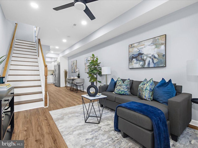 living room featuring wood-type flooring and ceiling fan