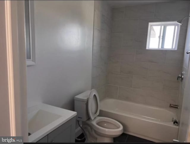 full bathroom with toilet, vanity, and tiled shower / bath