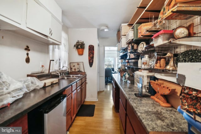 3536 Minnesota Ave SE, Washington, DC 20019 - kitchen with light wood-type flooring, stainless steel dishwasher, white cabinets, and dark countertops