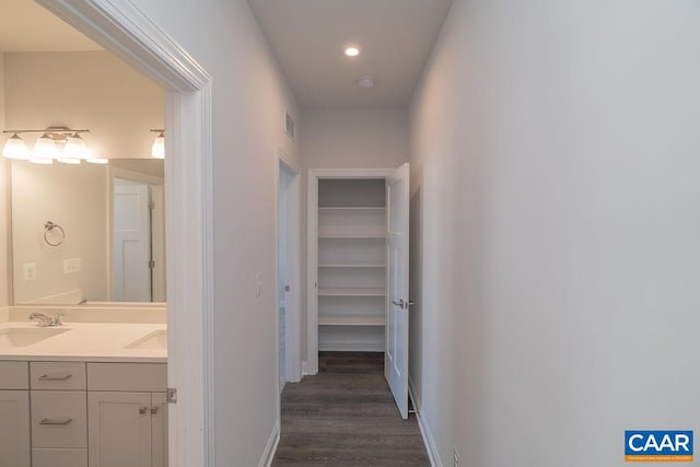 corridor with sink and dark wood-type flooring