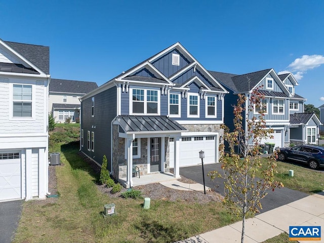 view of front of property with cooling unit, a garage, and a front lawn