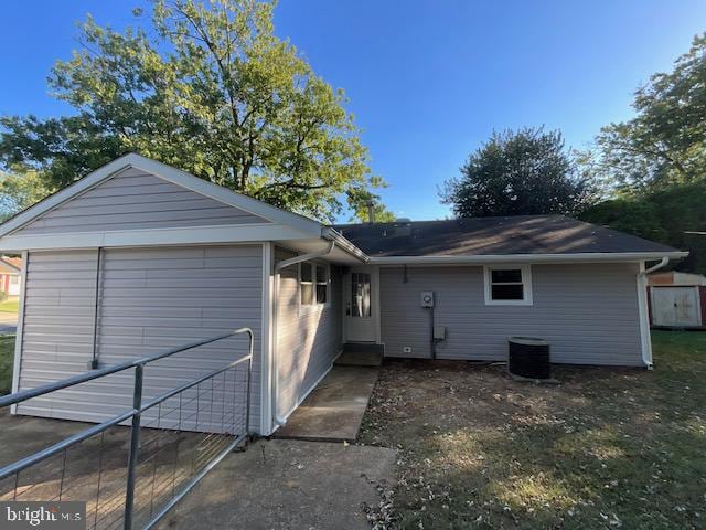 exterior space with a garage, cooling unit, and an outdoor structure