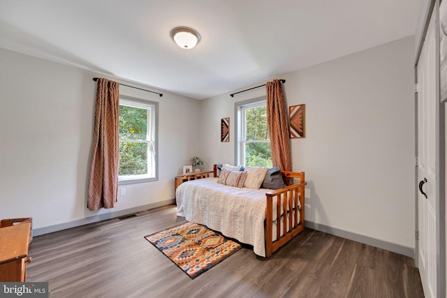 bedroom with dark hardwood / wood-style floors