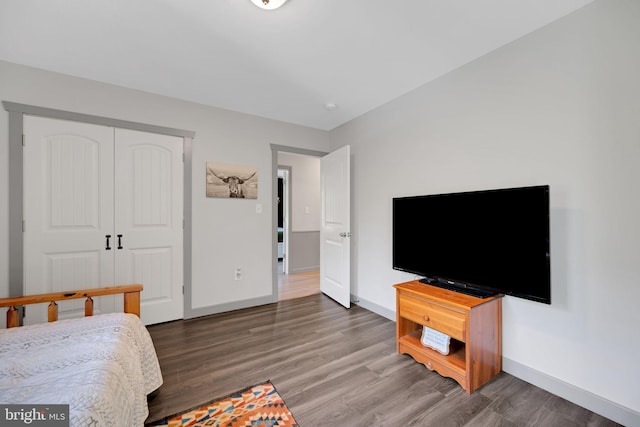 bedroom with a closet and dark wood-type flooring