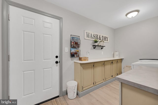 bar featuring green cabinetry, light hardwood / wood-style floors, and washing machine and dryer