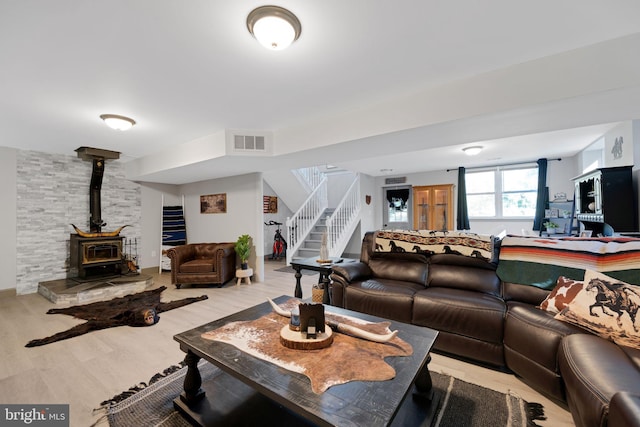 living room with a wood stove and light hardwood / wood-style floors