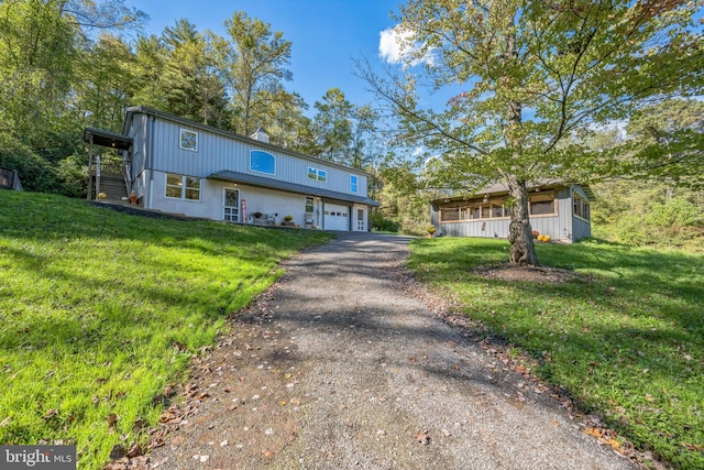 view of front of house featuring a front lawn, covered porch, and a garage