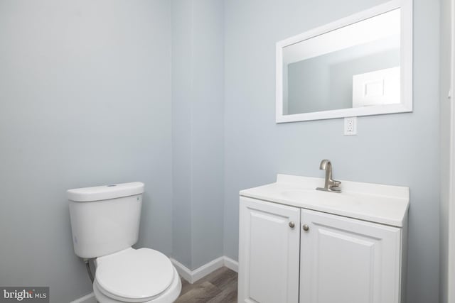 bathroom featuring hardwood / wood-style floors, vanity, and toilet