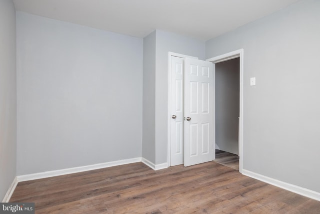 unfurnished room with dark hardwood / wood-style flooring