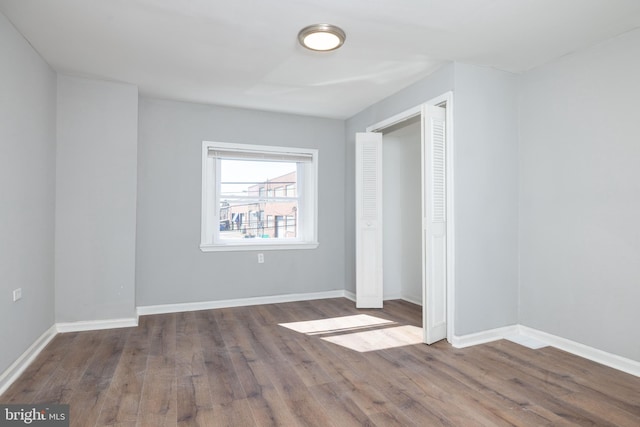 unfurnished bedroom with wood-type flooring and a closet