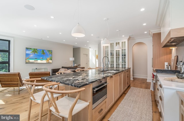 kitchen featuring dark stone countertops, light hardwood / wood-style floors, appliances with stainless steel finishes, and sink