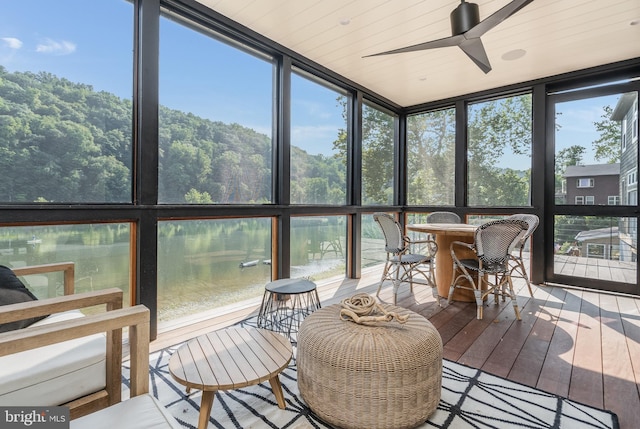 sunroom / solarium with a water view, ceiling fan, and plenty of natural light