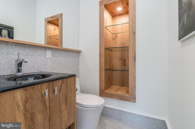 bathroom featuring walk in shower, vanity, toilet, and decorative backsplash