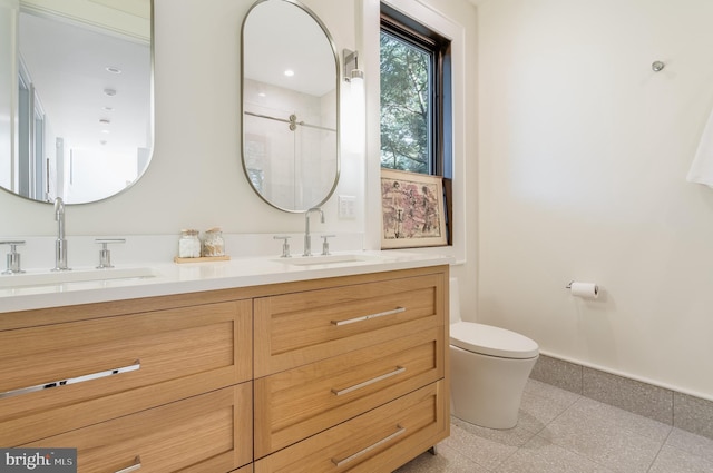 bathroom with walk in shower, vanity, and toilet