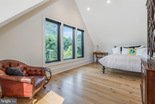 bedroom with light wood-type flooring and vaulted ceiling