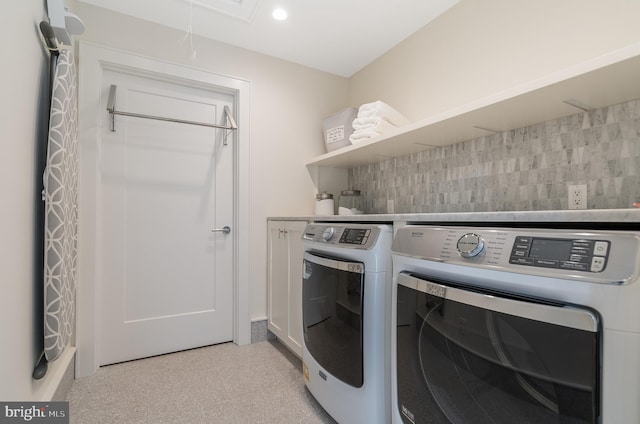 laundry area featuring washing machine and dryer and cabinets